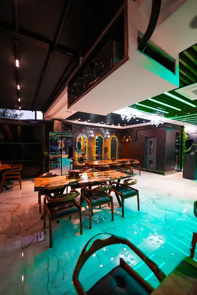 Salon girişinden epoksi masalar ve kemerli aynalara bakış