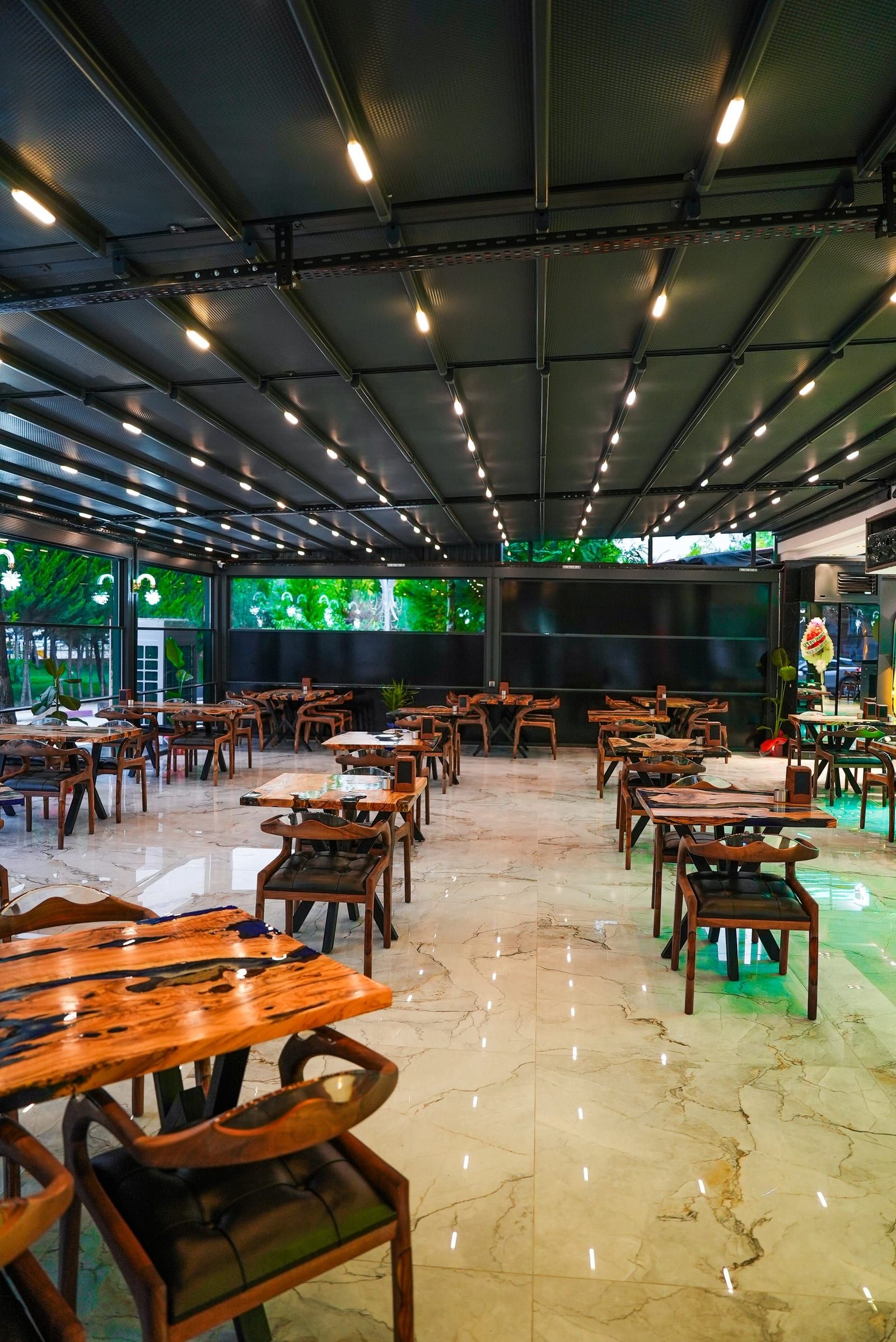 Pergola çatılı geniş kapalı teras ve masalar