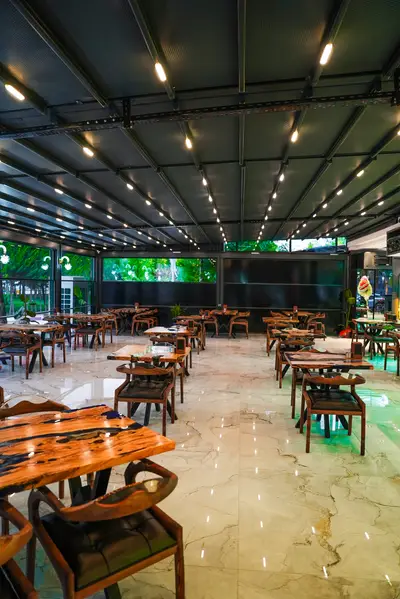 Pergola çatılı geniş kapalı teras ve masalar